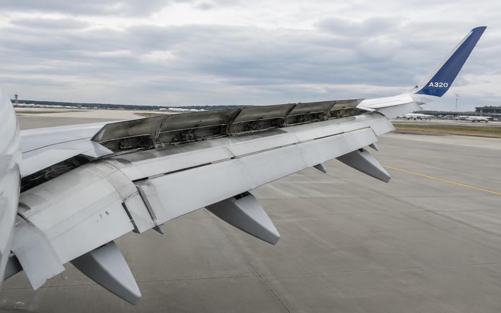 Wing with spoilers, flaps and flap-track fairings